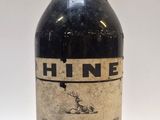 une vieille bouteille de vin posée sur une table blanche