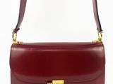 un sac à bandoulière en cuir rouge avec un fermoir doré