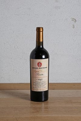 a bottle of red wine sitting on a wooden table