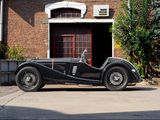 a black vintage car parked in front of a brick building