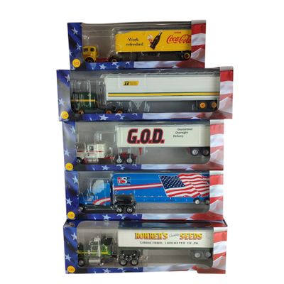 Plusieurs camions miniatures sont empilés les uns sur les autres dans une vitrine.