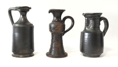 trois vases posés l'un à côté de l'autre sur une surface blanche