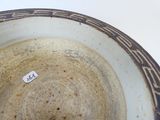 un bol blanc et bleu sur lequel est collé un autocollant