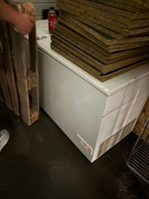 a man that is standing next to a stack of wood