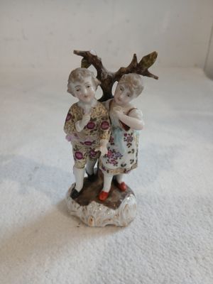 une figurine représentant deux enfants debout l'un à côté de l'autre