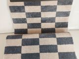 La couverture est en laine et présente un motif à carreaux.