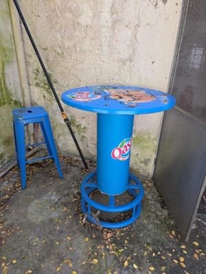 une table bleue et un tabouret bleu devant un mur