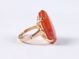 a close up of a ring with an orange stone on it