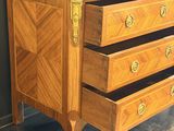 a wooden chest of drawers with brass hardware on it