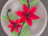 une plaque de verre sur laquelle est représentée une fleur rouge