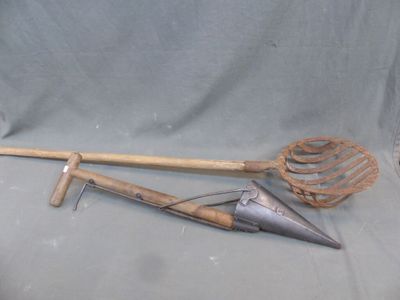 un objet métallique muni d'un manche en bois sur fond gris