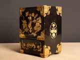 une armoire noire et dorée ornée d'un motif floral