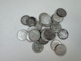 une pile de pièces d'argent posée sur une surface blanche