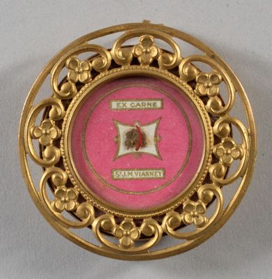 une image représentant une broche rose et dorée ornée d'une rose au centre