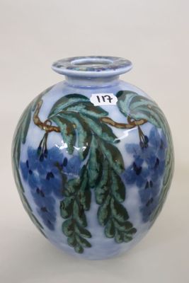 a blue vase with green leaves on it on a white background