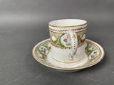 a small cup and saucer on the table