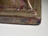 a silver statue of a bird sitting on top of a book