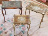 trois tables posées sur un tapis au sol
