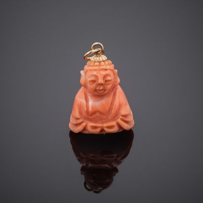 an orange jade buddha pendant on a black surface