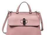 un sac à main en cuir rose orné d'une boucle métallique sur le devant