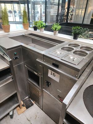 une cuisine avec de nombreux plans de travail en inox
