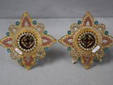 une paire de boucles d'oreilles dorées ornées de pierres multicolores et de perles