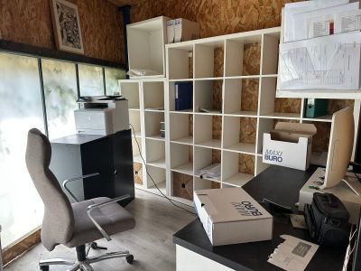 un bureau avec un ordinateur et une chaise dans une pièce