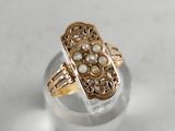 a close up of a gold ring with pearls on it