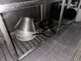 pots and pans sitting on a metal shelf in a kitchen