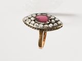 un gros plan d'une bague ornée d'une pierre rose entourée de diamants