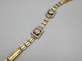 an image of a gold and silver bracelet on a white surface
