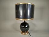 une lampe noire et dorée, munie d'un abat-jour noir