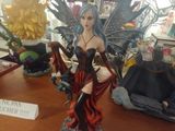 a statue of a fairy sitting on top of a wooden table