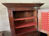 an old wooden cabinet with a red and yellow pattern on it