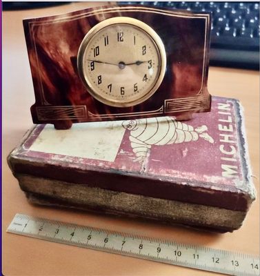 une horloge posée sur un livre, à côté d'une règle