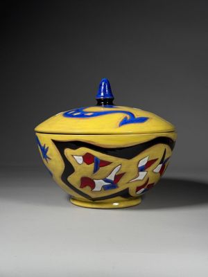 an image of a yellow bowl with a blue lid sitting on a table