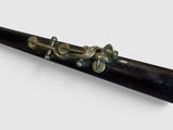 a black pipe with a brass handle on a white surface