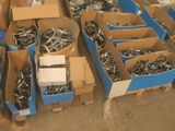 de nombreuses boîtes de vis et de boulons sur une palette