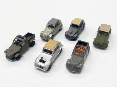 six petites voitures alignées sur une surface blanche