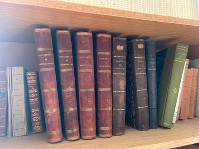 de nombreux livres anciens posés sur une étagère en bois dans une pièce