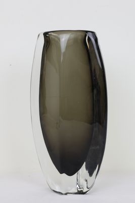 un vase noir et blanc posé sur une surface blanche