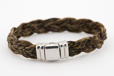 un gros plan sur un bracelet tressé orné de deux perles en argent