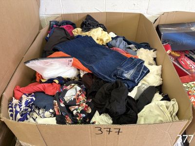 a cardboard box filled with clothes and other items