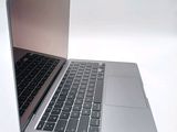a silver laptop with a black keyboard on a white surface