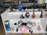 une étagère blanche sur laquelle sont posés de nombreux objets, dans une pièce