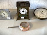 trois horloges et une horloge posée sur une table, les unes à côté des autres