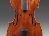 un vieux violon sur lequel repose un archet en bois