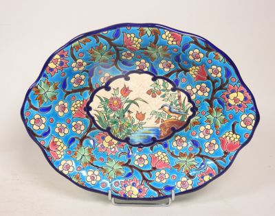 une assiette bleue décorée de fleurs et d'oiseaux