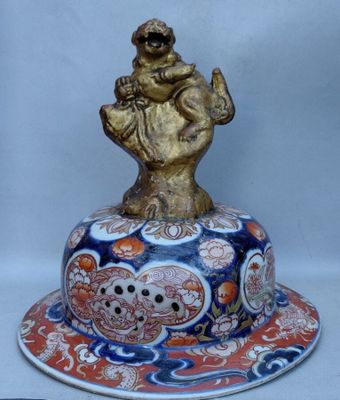 une figurine représentant un homme tenant un oiseau, posée sur une assiette