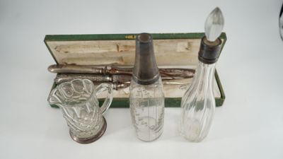 des biberons et des cuillères dans un étui posé sur une surface blanche